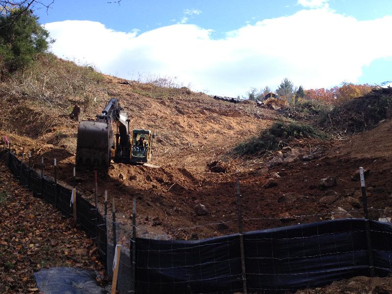 After clearing, this excavator is removing organics and preparing the area for compacted fill. 